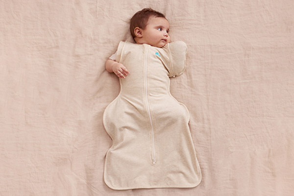 Baby ligt en heeft een Love to Dream™ Transition Bag aan