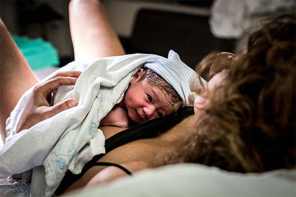 Baby Mae net na de geboorte op buik van moeder Lisa